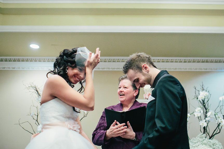 a funny moment during a wedding ceremony at a Queen's Landing Hotel wedding by Toronto fine art wedding photographer