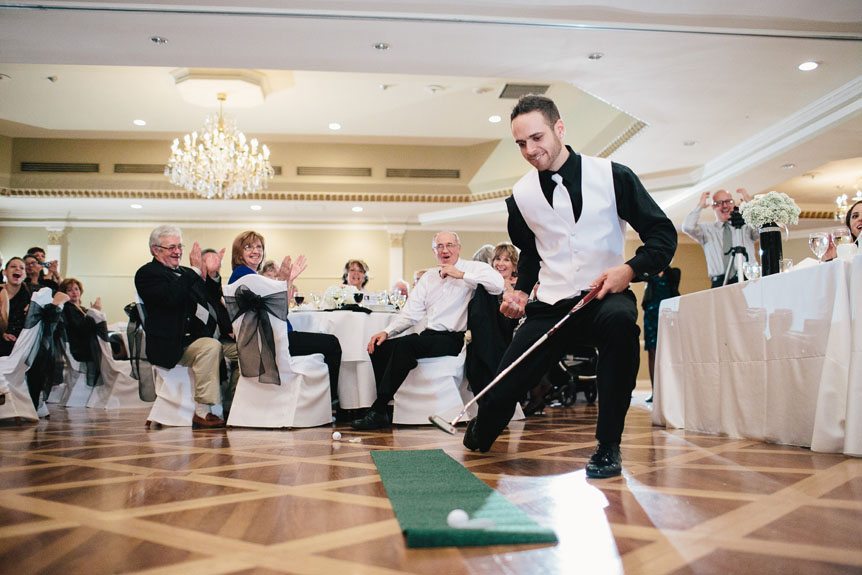 a groom plays a putting game at their Queen's Landing Hotel wedding during their reception