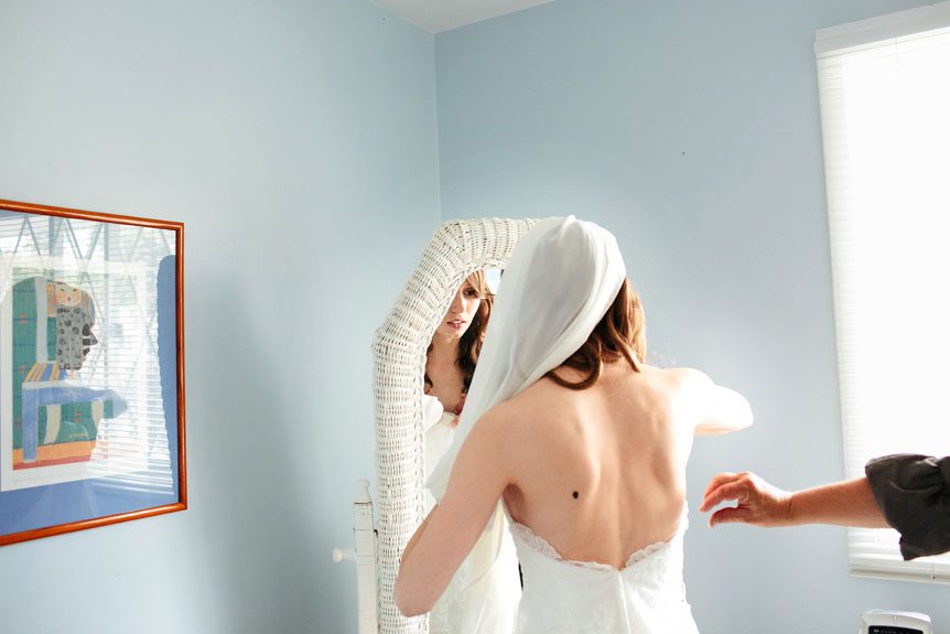 Cambridge Documentary Wedding Photographer photographs the bride as she puts her gown on.