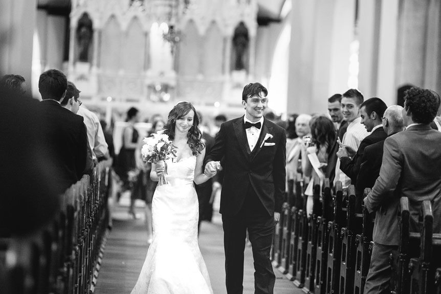 Cambridge Documentary Wedding Photographer captures the bride and groom walk up the aisle after their wedding ceremony at the Church of Our Lady Immaculate.