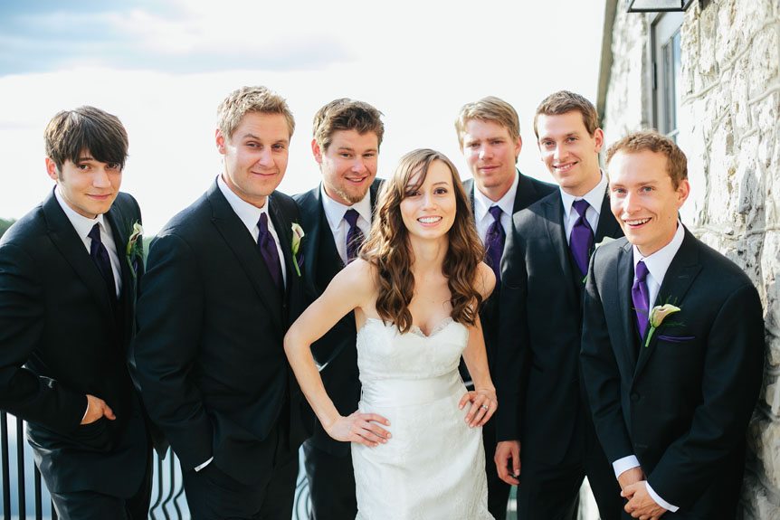 The bride and the groomsmen poses for a portrait at a Cambridge Mill wedding with Cambridge Documentary Wedding Photographer.