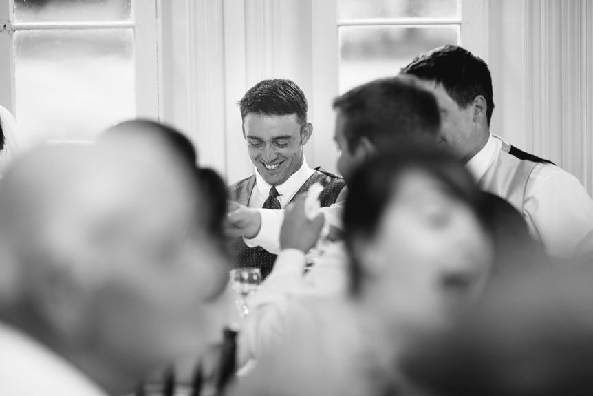 Documentary Style Wedding Photography studio captures the groom's reaction at the speeches at their Penryn Mansion wedding.