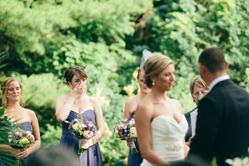 The bride's sister sheds a tear at a Langdon Hall outdoor wedding ceremony as photographed by Toronto wedding photographer.