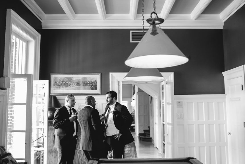 The groomsmen hangs out with each other before a Langdon Hall outdoor wedding as photographed by Toronto wedding photographer.