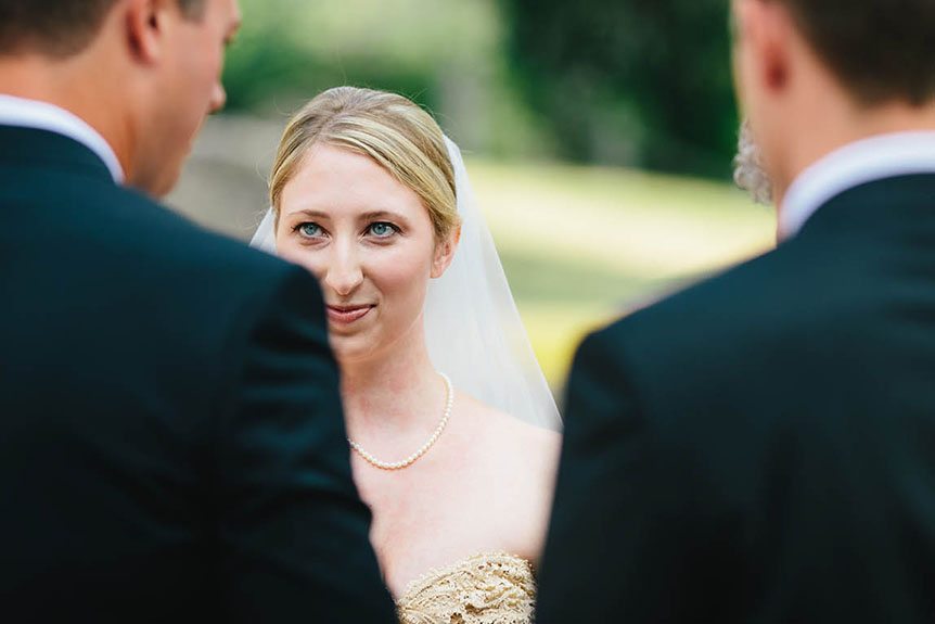 Cambridge Documentary Wedding Photographer captures a candid moment as the bride looks at her groom during their wedding ceremony,