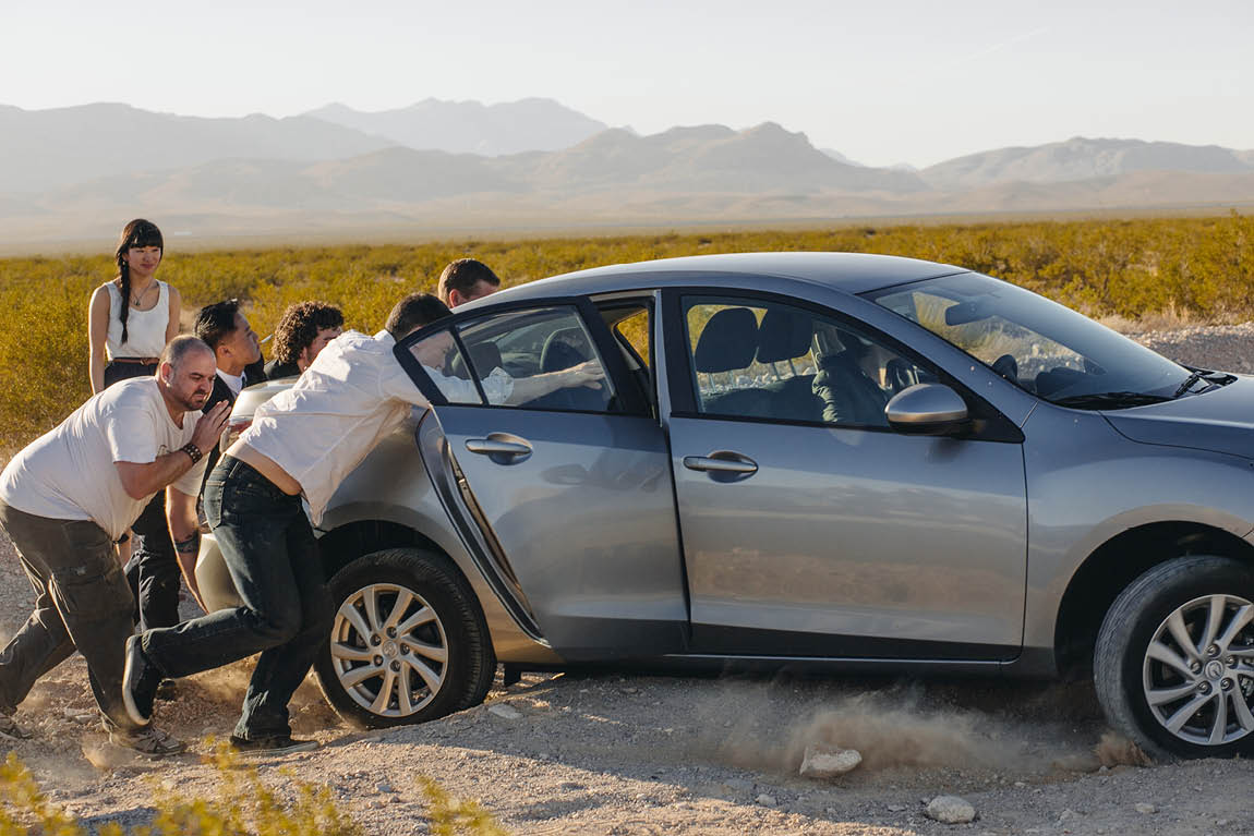 Toronto photographer photographs photographers helping a car get out of a sandy bump.