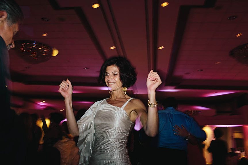 One of the wedding guests at a Burlington Convention Center wedding reception is photographed by Toronto documentary wedding photographer dancing.