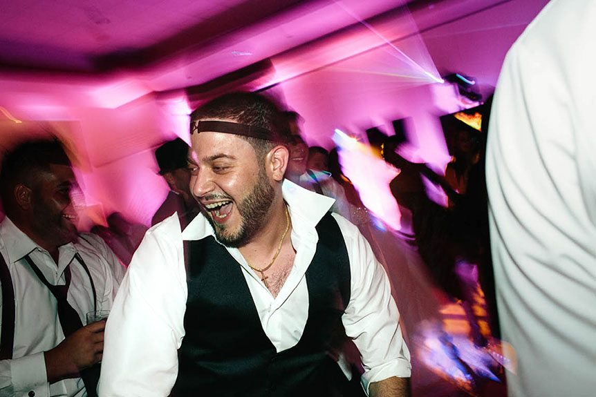 Toronto documentary wedding photographer captures a groom enjoying his wedding reception at the Burlington Convention Center.