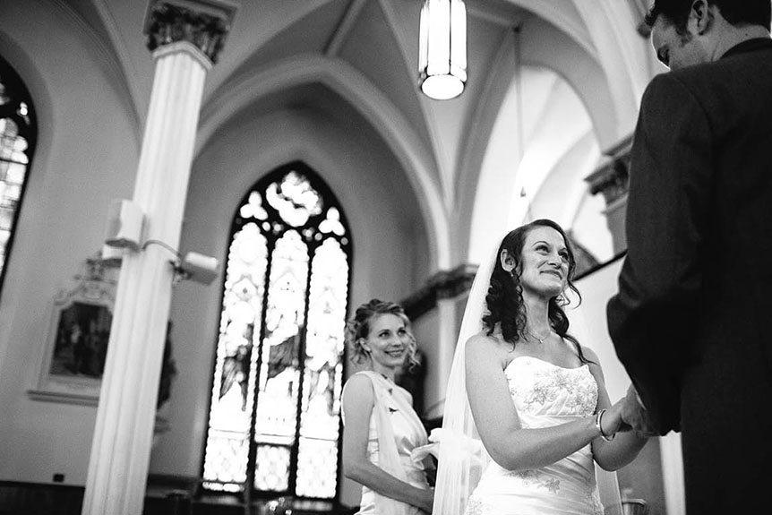 The bride listens to the groom's vows as photographed by Ingersoll wedding photojournalist.