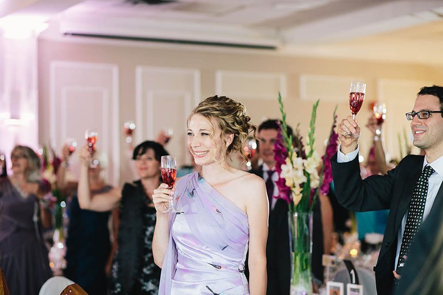 Wedding guests at an Elm Hurst Inn reception toast to the bride and groom.