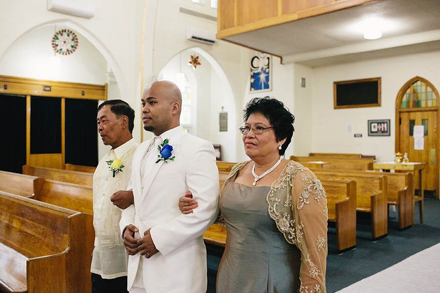 A Filipino groom and his parents walk down the aisle.