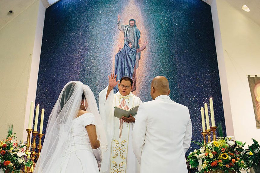 A roman catholic priest performs a wedding ceremony.