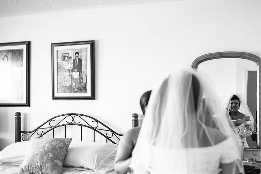 A Toronto bride sees herself in the mirror dressed up as a bride.