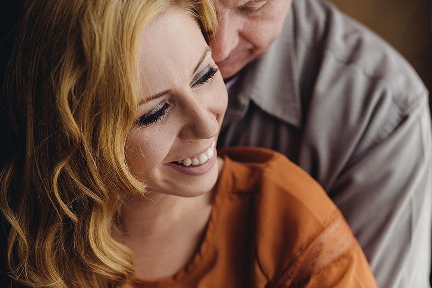 Beautiful couple photographed by a Kitchener photography studio cuddles with her fiance.