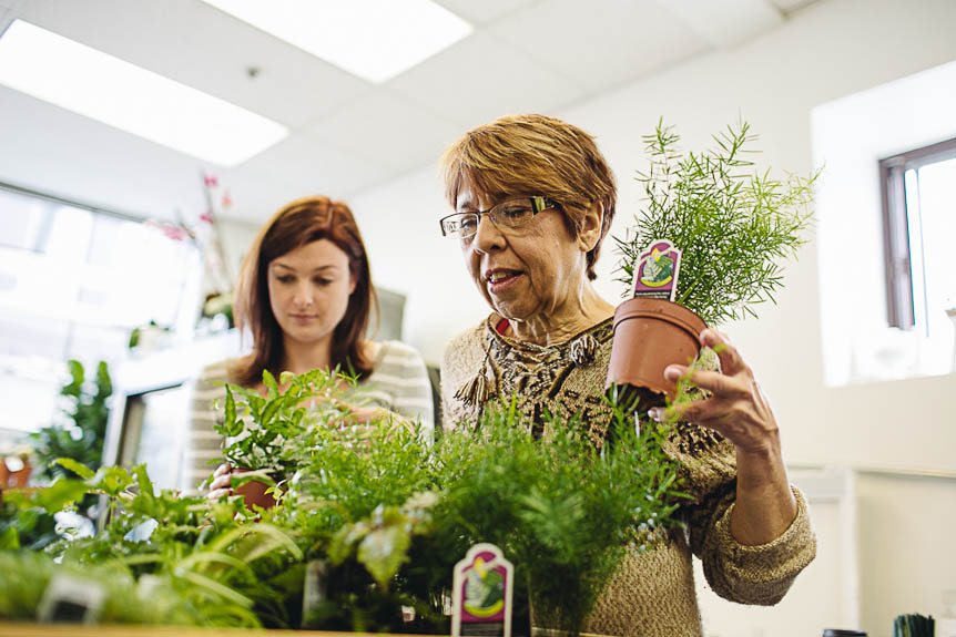 A mother and daughter attending a floral design class together pick which plants to include.