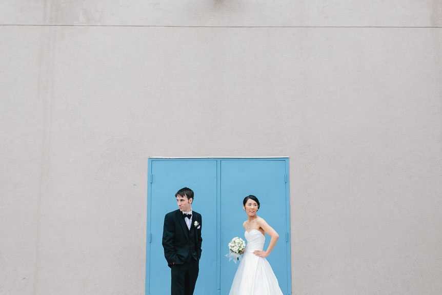 The bride and groom in front of a blue door photographed by Mississauga wedding photographer.