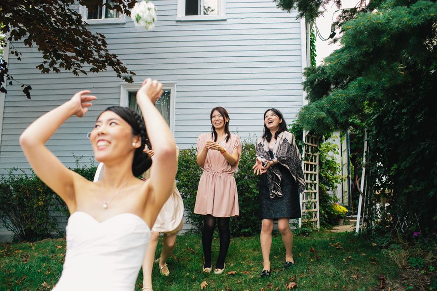 The bride at an intimate Port Credit wedding throws away her bouquet.