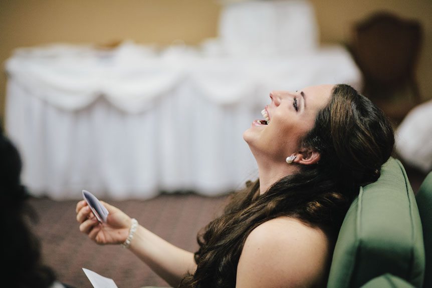 Maid of honour laughs at something she read in a letter written by the bride.