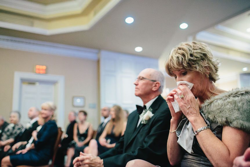 The bride's mother get emotional at a Queen's Landing Hotel indoor wedding ceremony.
