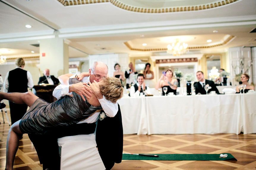The bride's parents kiss passionately,