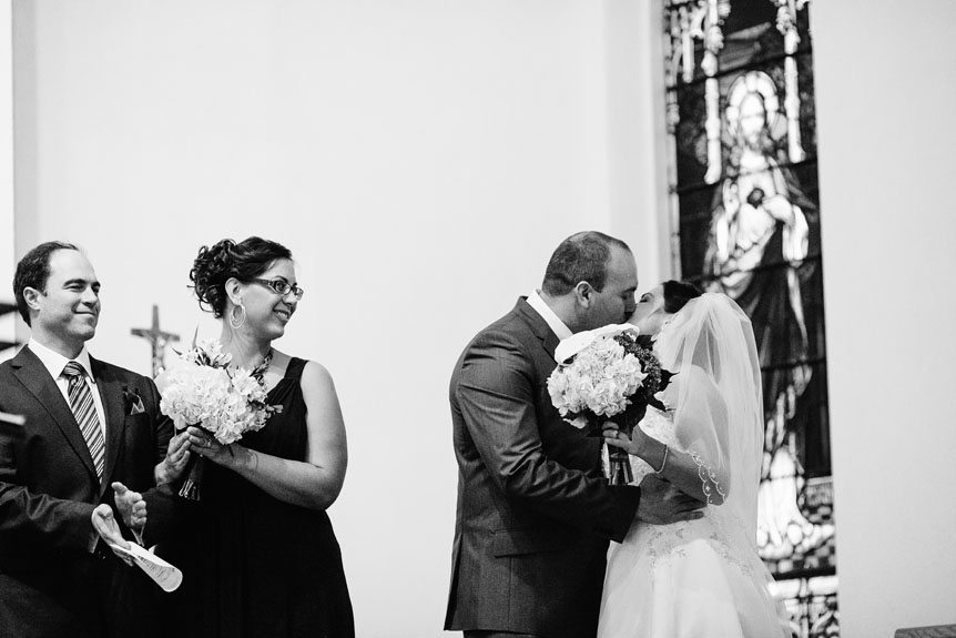 The first kiss of the bride and groom at a Roman Catholic church.