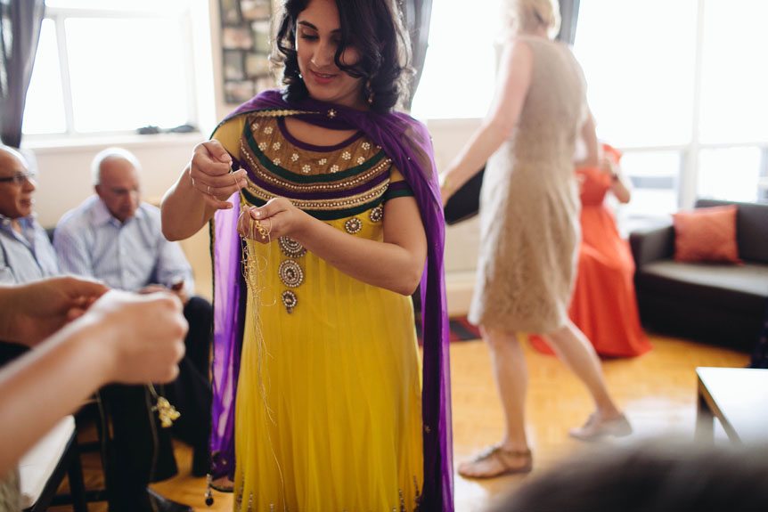 Indian bride in Toronto attends to guest at her mehendi ceremony.