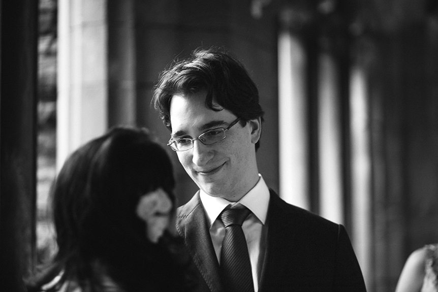 A black and white image of the groom during their wedding ceremony at Knox College.