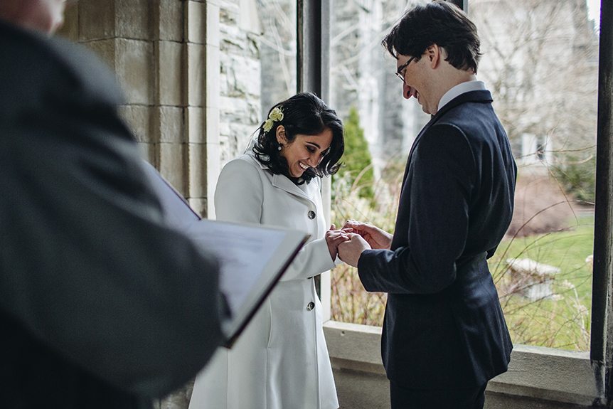 The bride receives her wedding ring from her groom at an intimate wedding ceremony in Toronto.