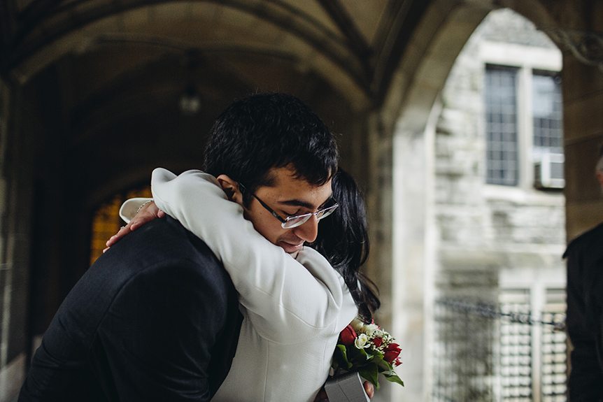 THe bride at an intimate Toronto wedding hugs her brother right after their ceremony.