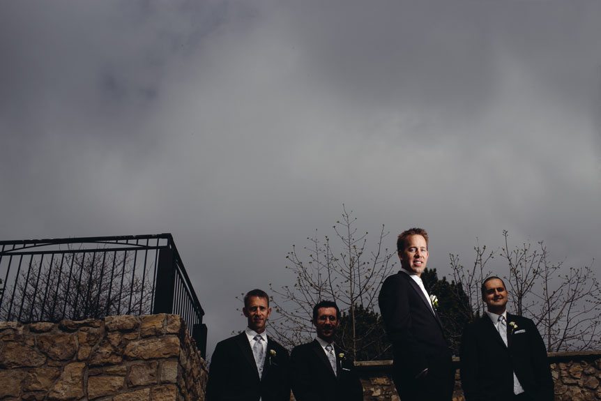 A dramatically lit portrait of the groom and his groomsmen.