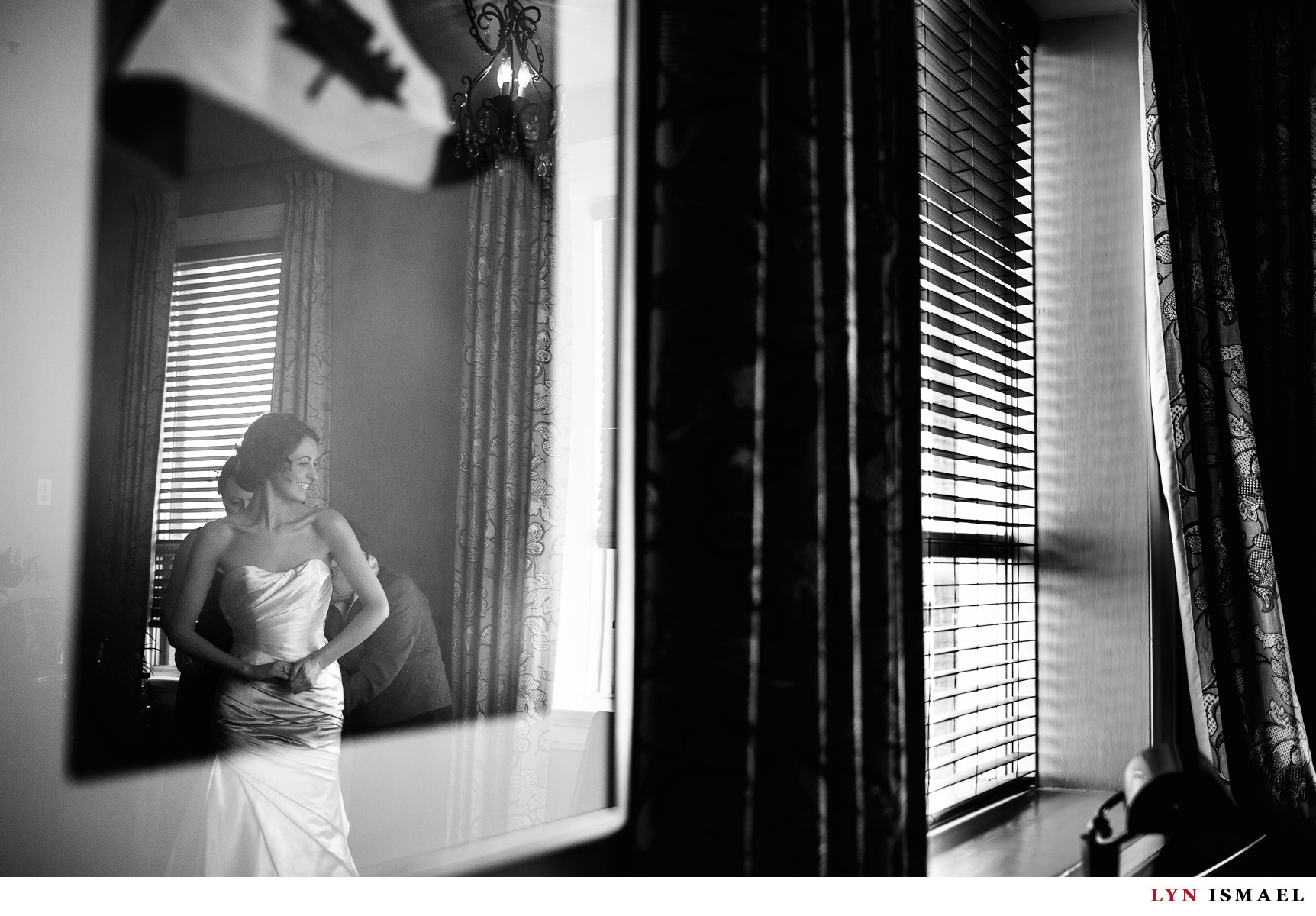 Bride is reflected on a framed print as she gets ready before her wedding at the Walper Hotel.
