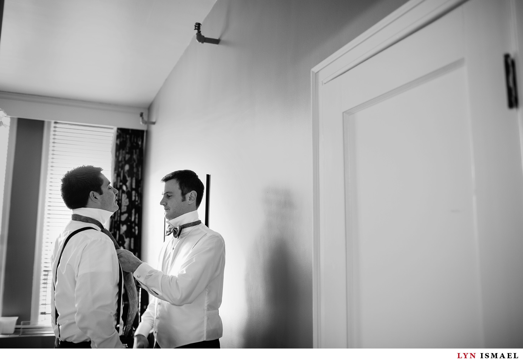 The groom is helped by his groomsman at the Walper hotel.