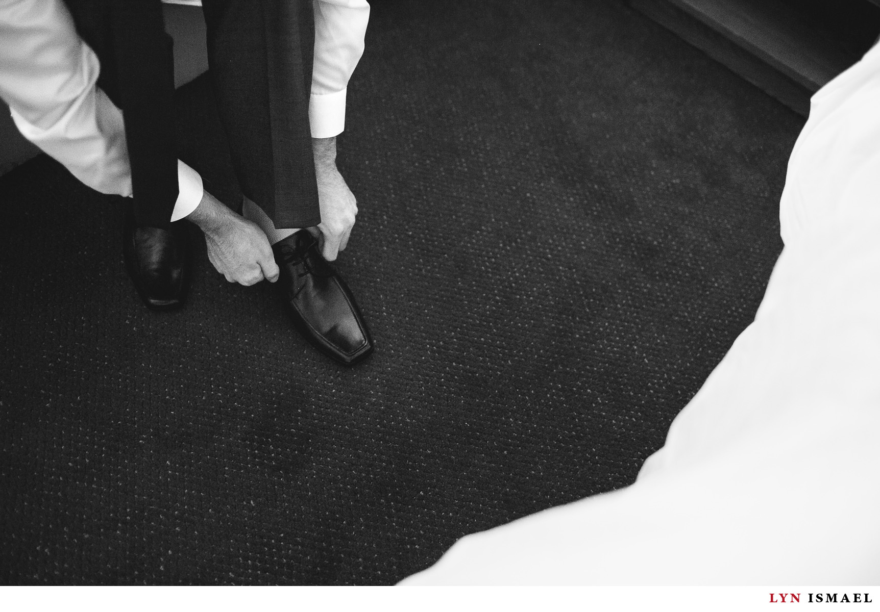 The groom puts his shoes on