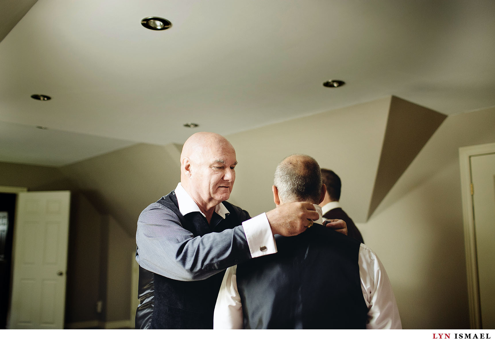 Father of the groom helps the groom get ready