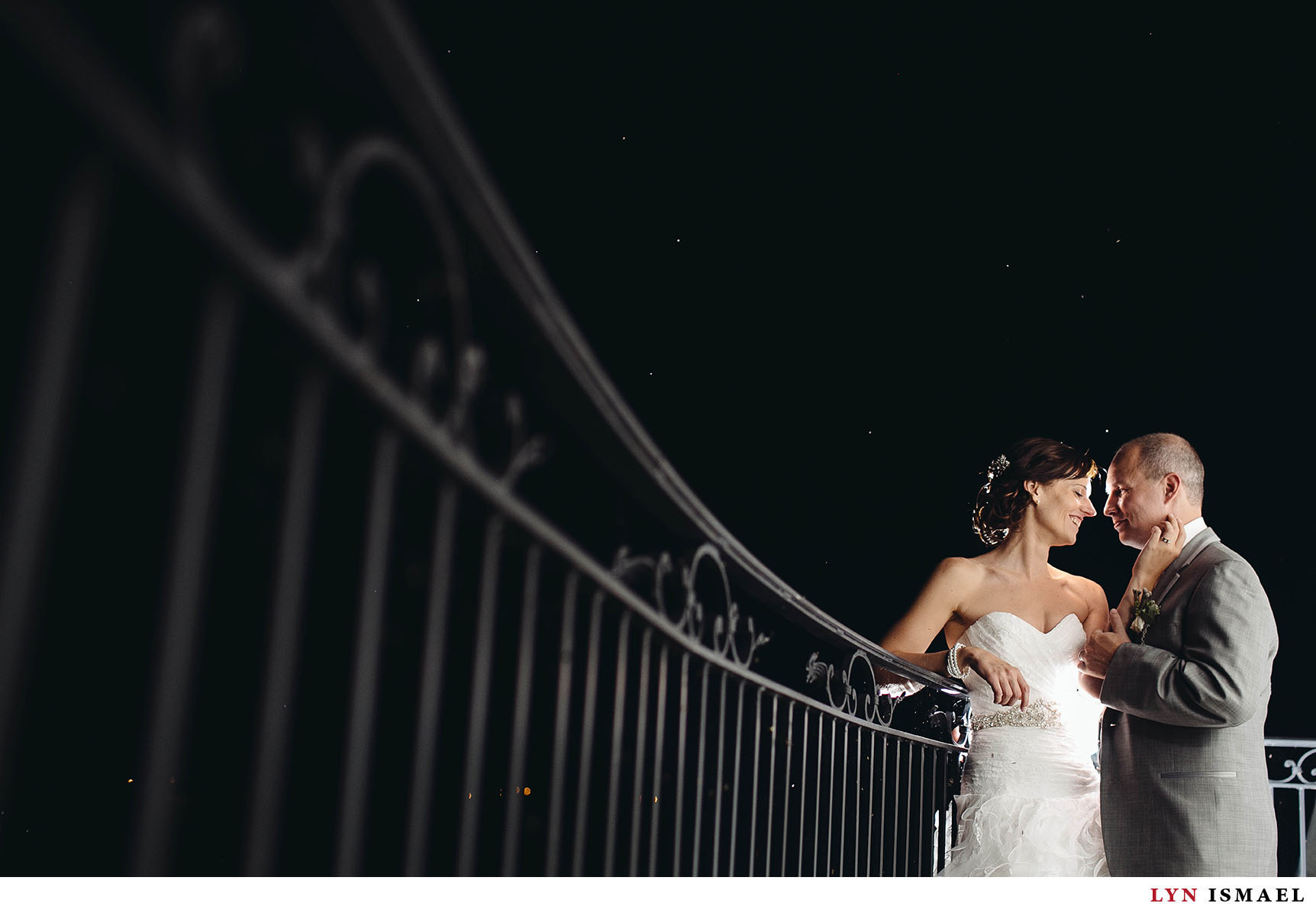 A night portrait of the bride and groom in Cambridge Mill by a creative wedding photographer.