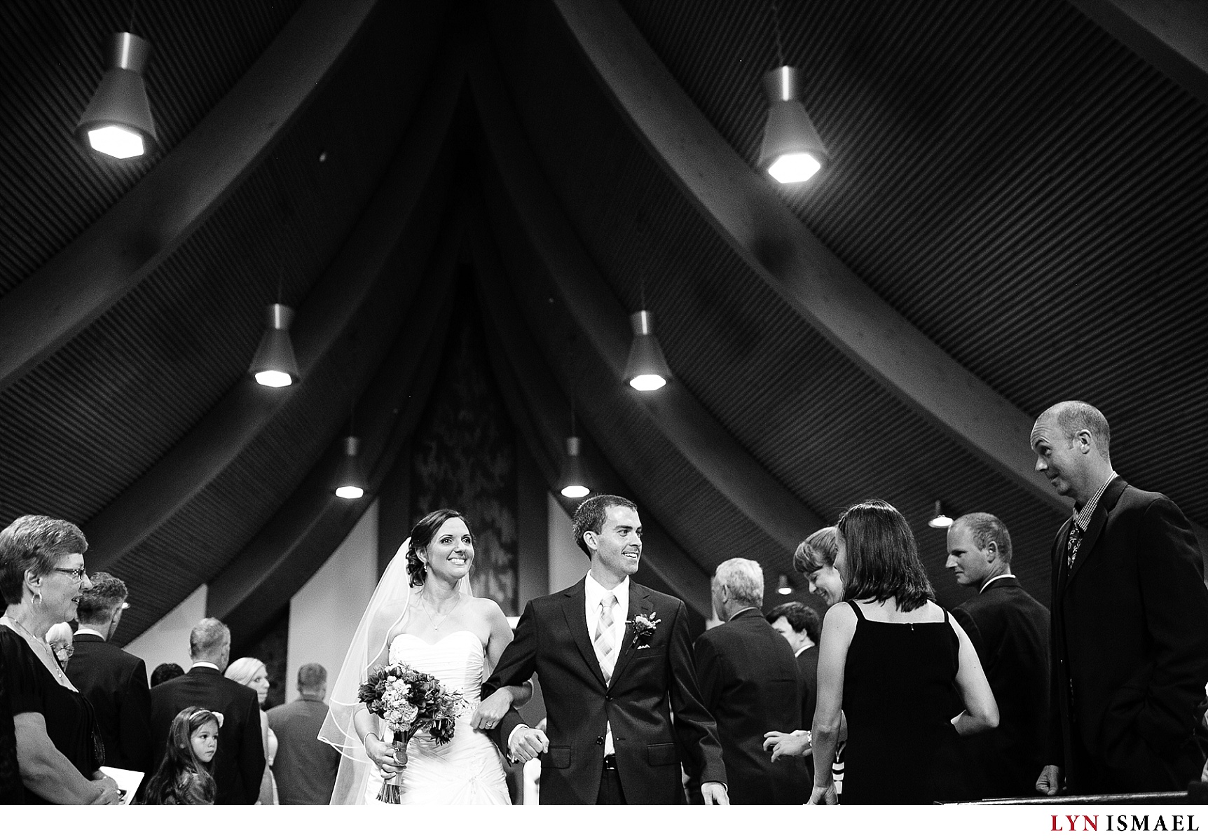A black and white image of the bride and groom walking down the aisle.