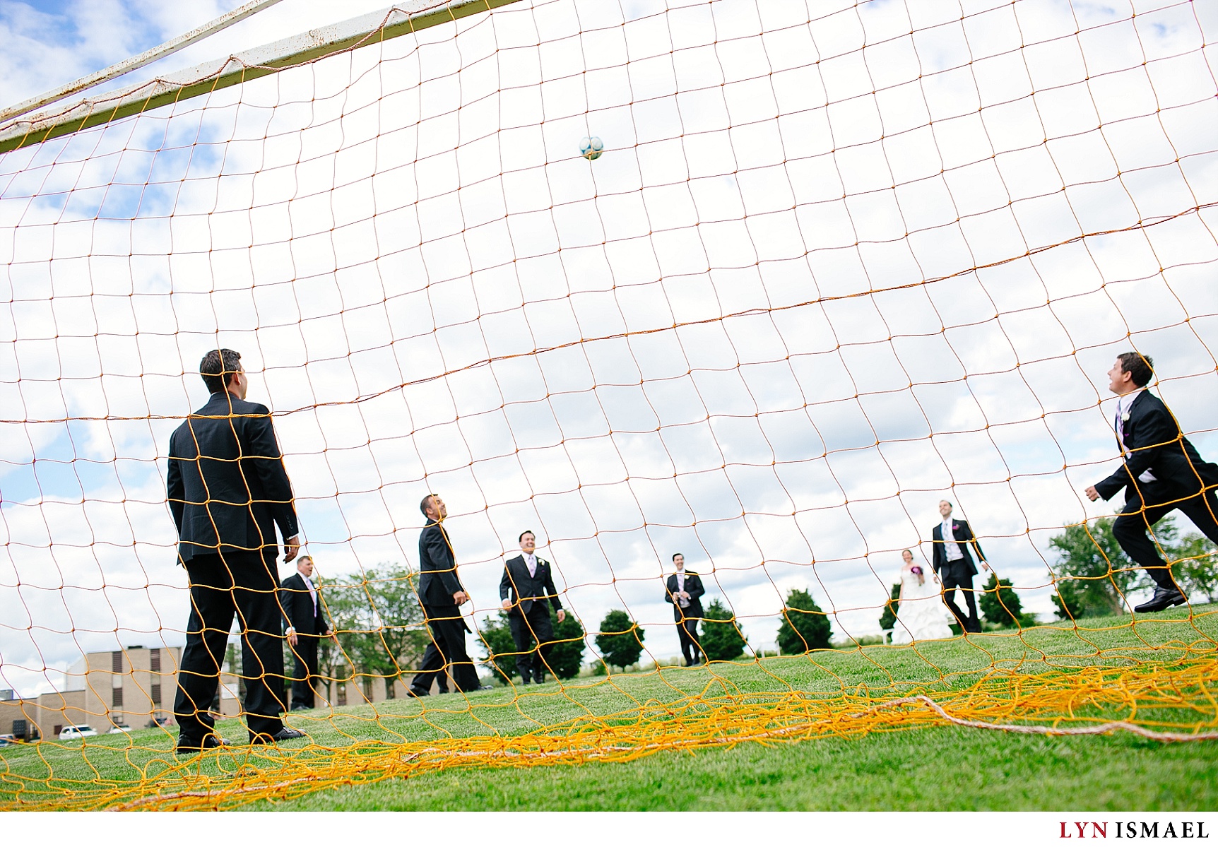 The wedding party plays soccer.