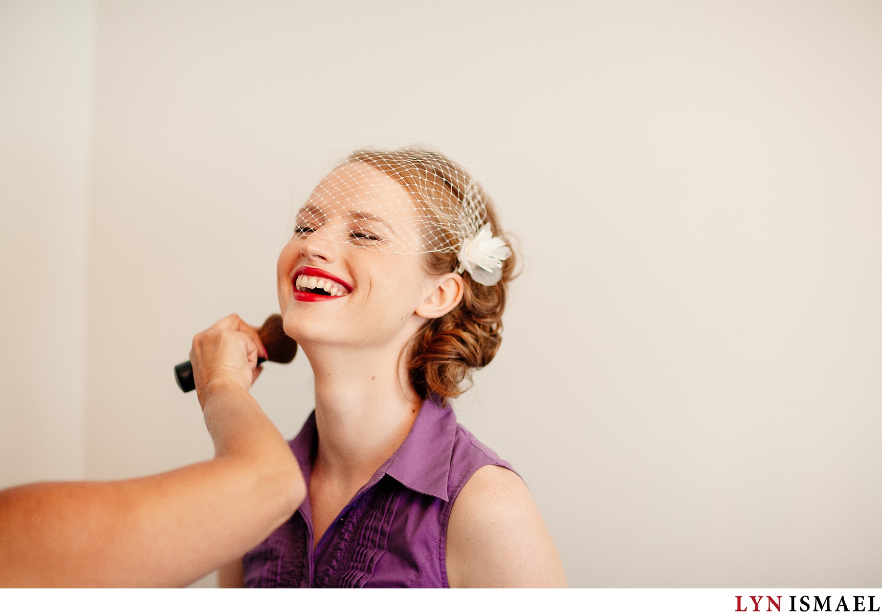 bride with red lips get her makeup done.