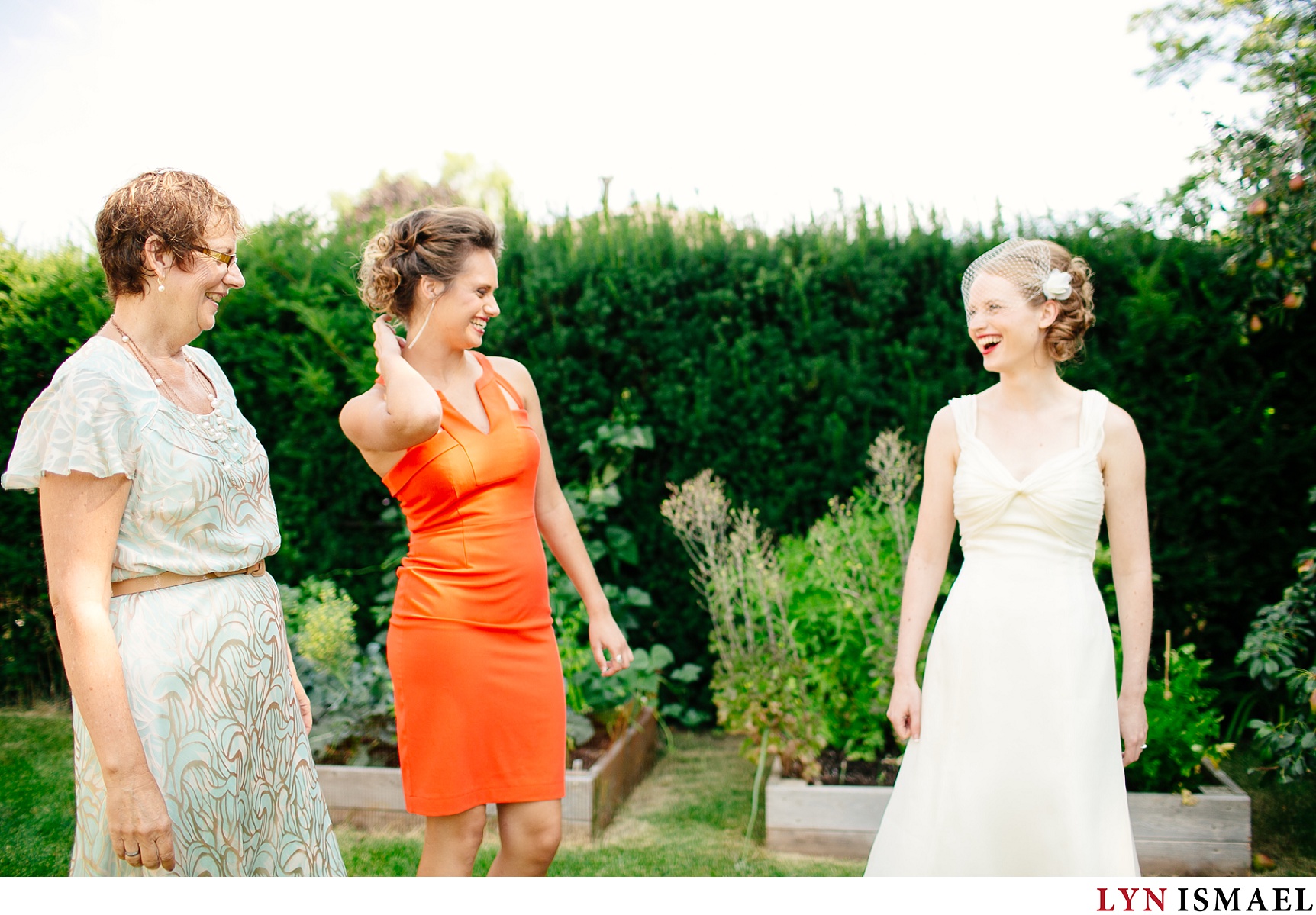 Mother of the bride, her sister, and the bride shares a laugh.