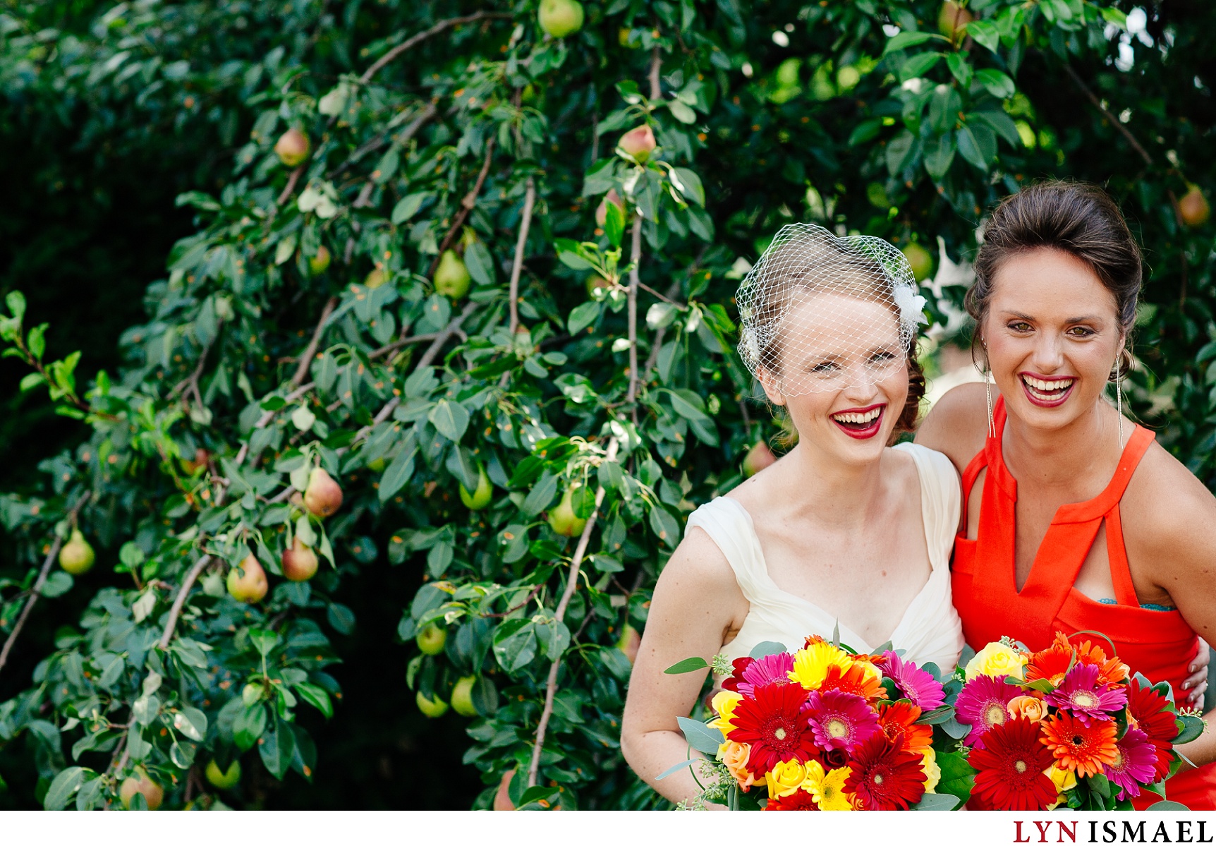 The bride with a colourful bouquet and a bridesmaid with orange dress.