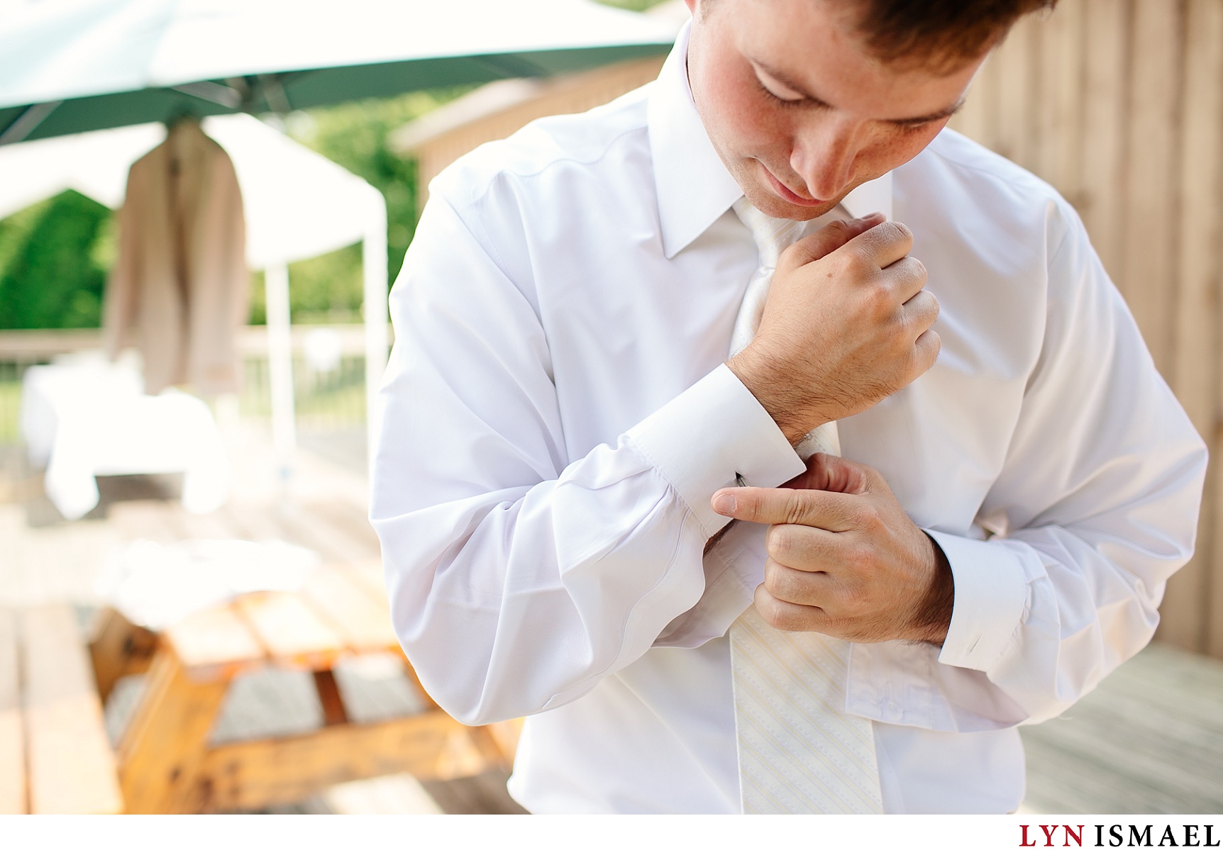 The groom puts his cufflinks on outside in Belwood Lake
