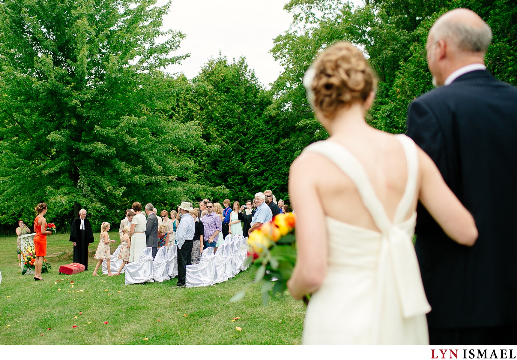 The guests watches the bride walk down the aisle.