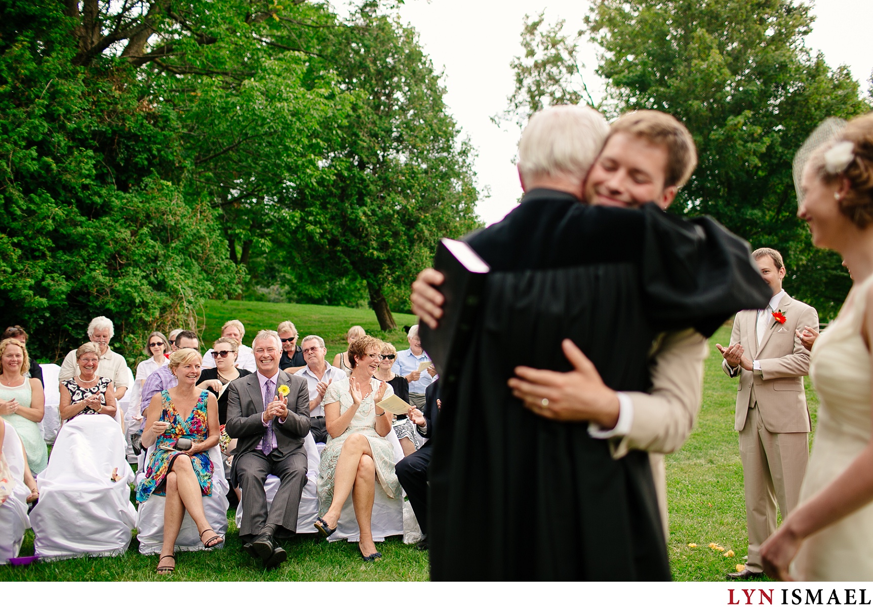 The bride's grandfather hugs her groom.