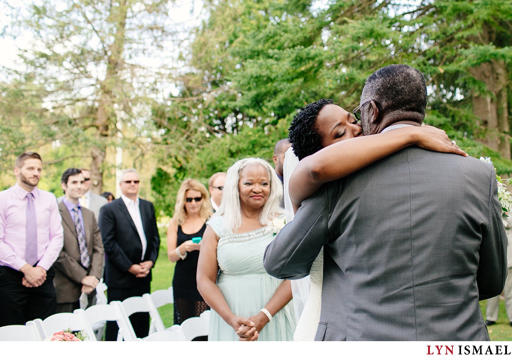 Mother of the bride watches as her daughter and hugs her father at the altar at a Holland Marsh Wineries wedding.
