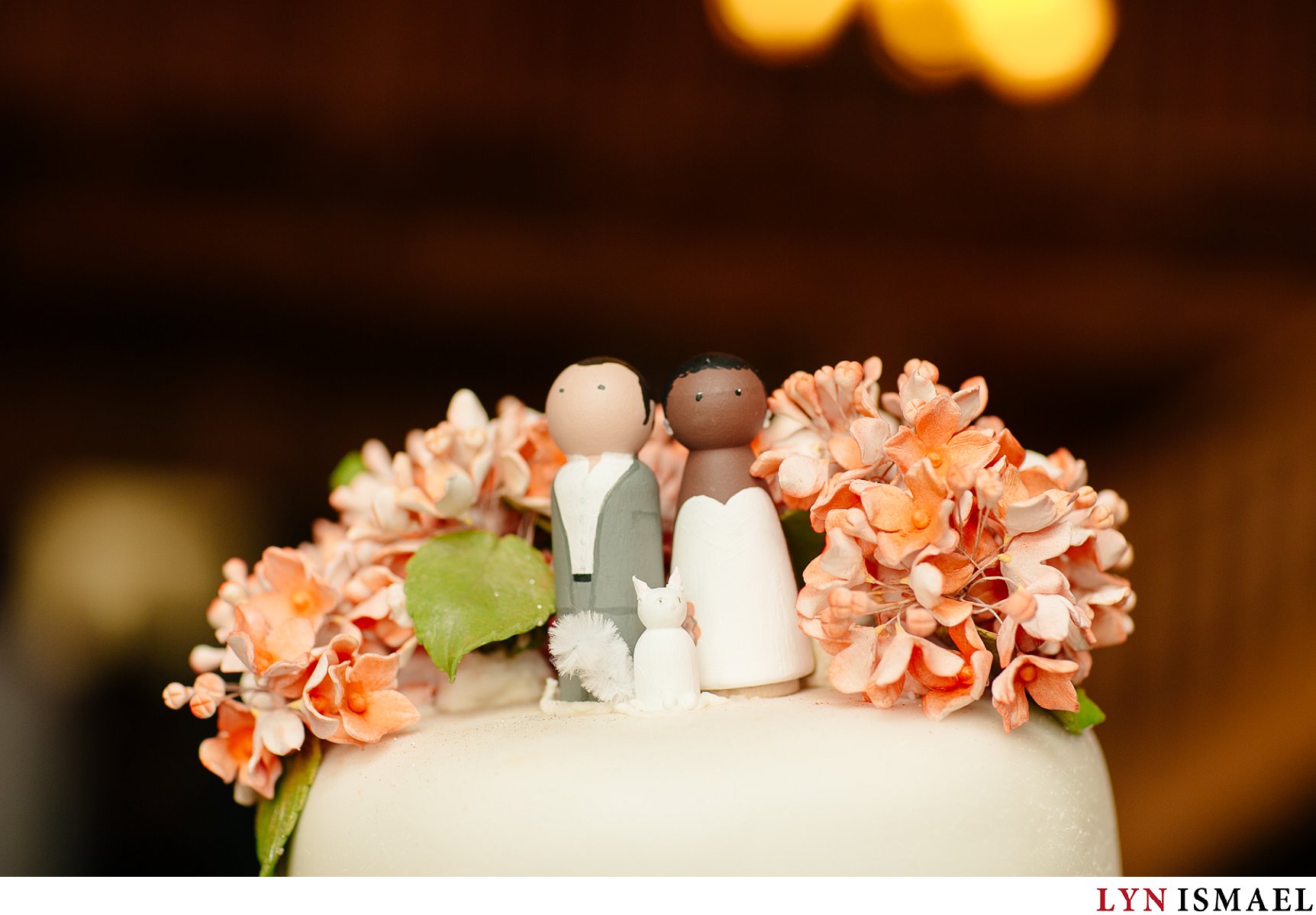 Cake topper featuring the bride and groom and their cat.