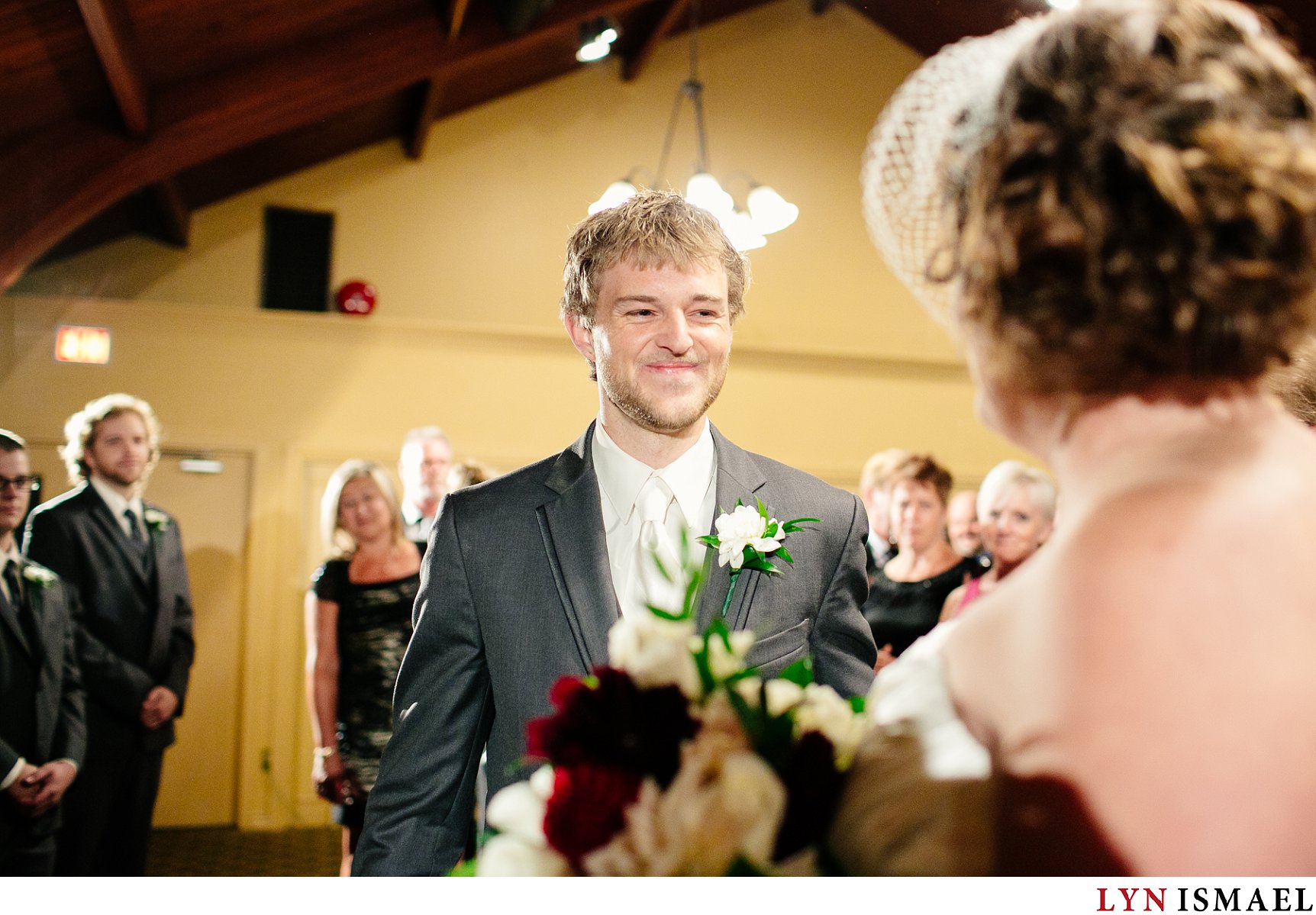 A very happy groom meets his bride at the altar.