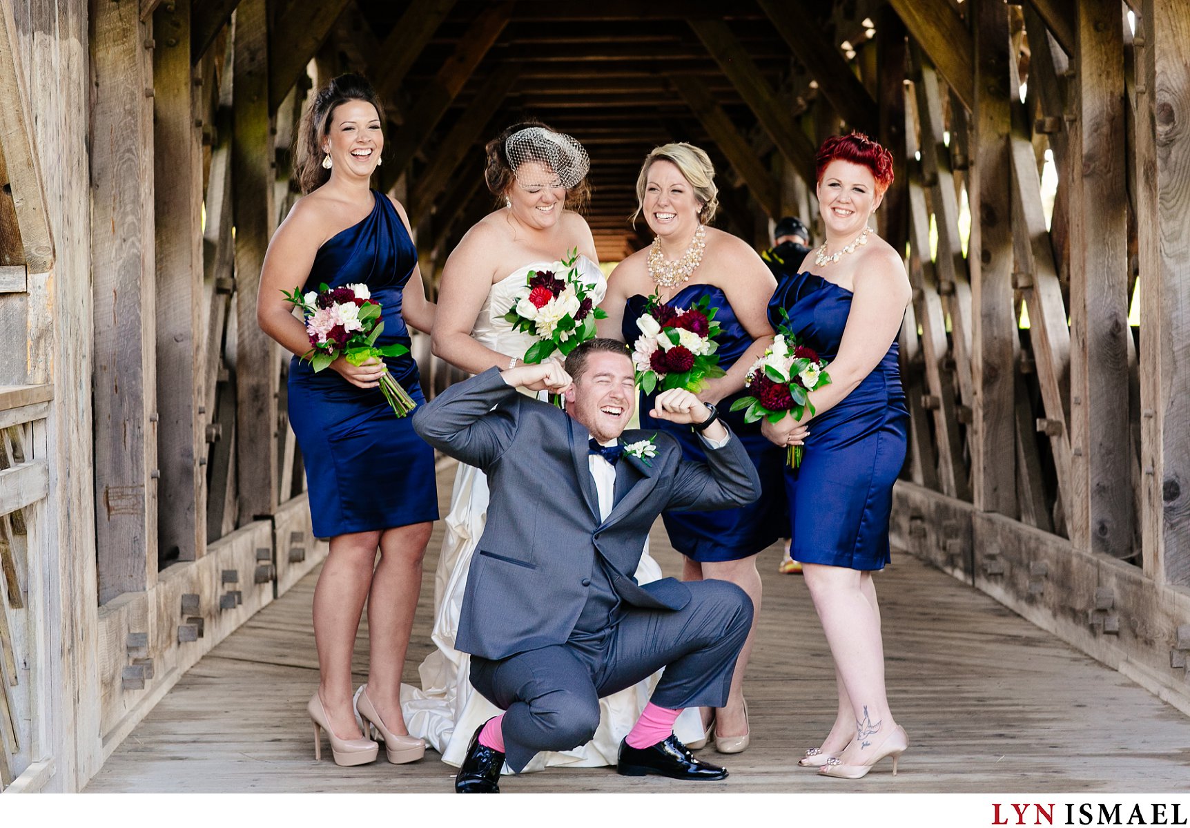Man of honour with pink socks hanging out with the bride and her bridesmaids.