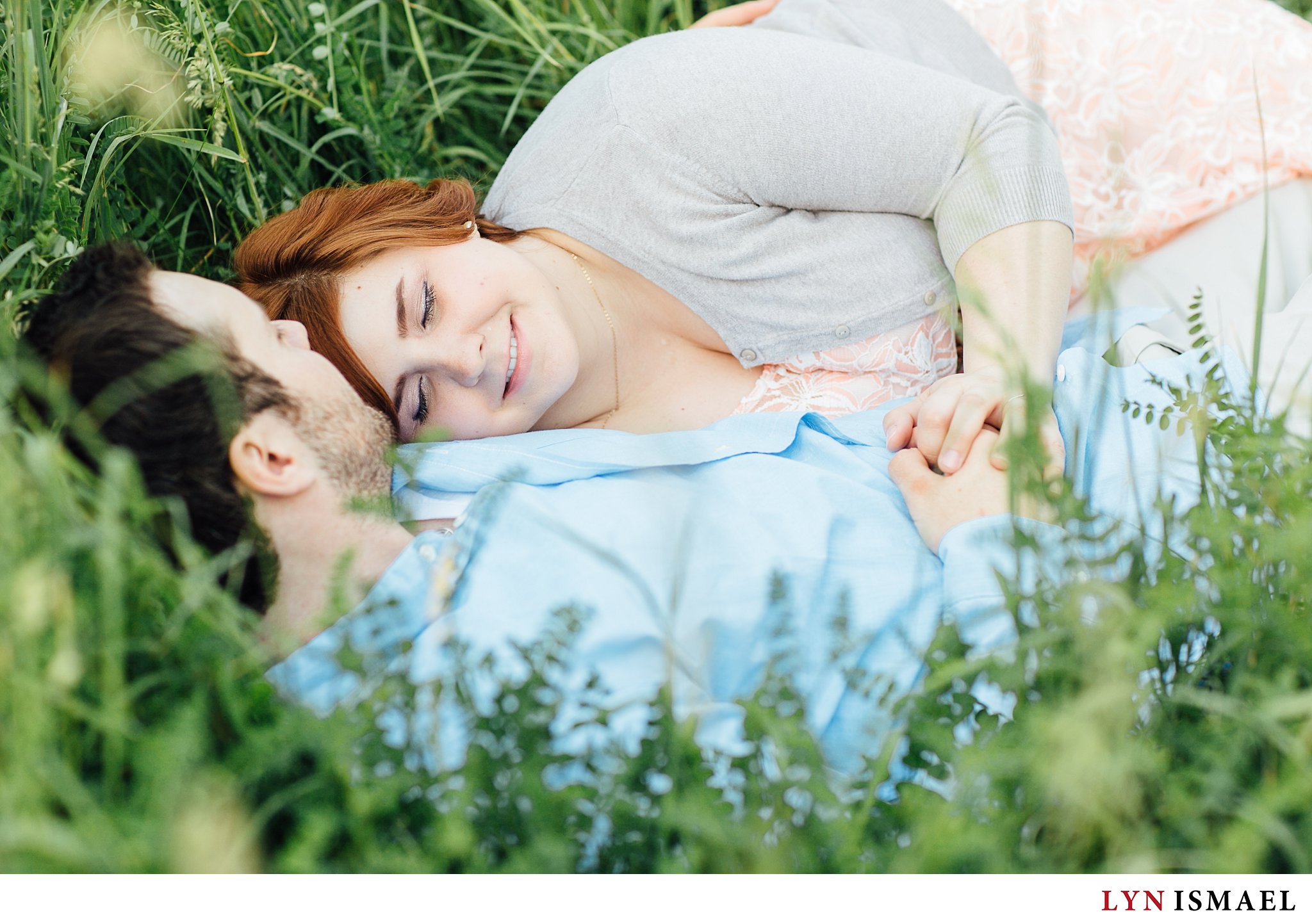 Newly engaged couple in Guelph cuddles on the grass.