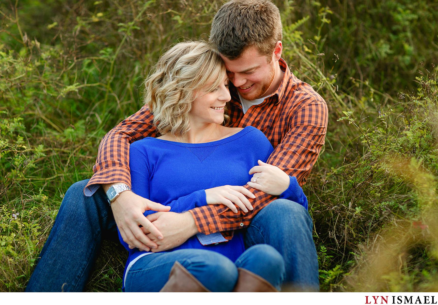 A couple snuggles at Huron Natural Area in Kitchener for their romantic engagement session