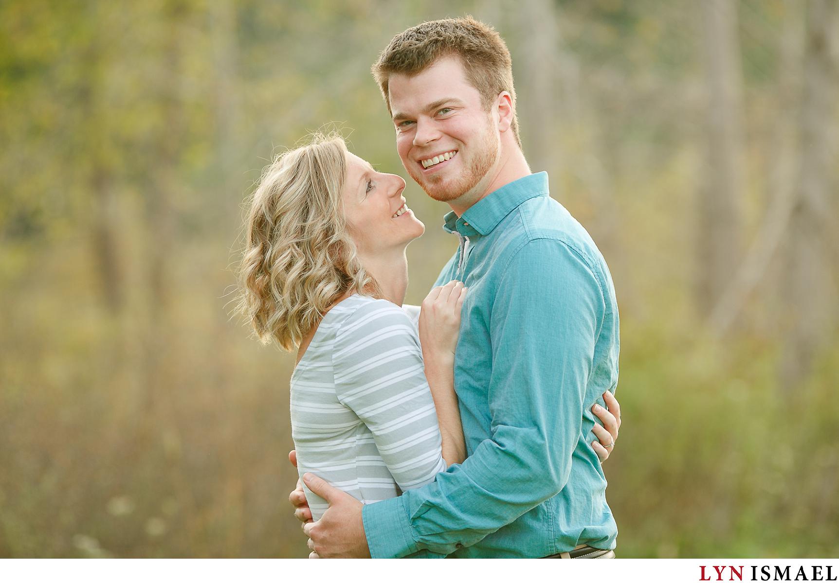 A blonde couple poses for their engagement session at Huron Natural area